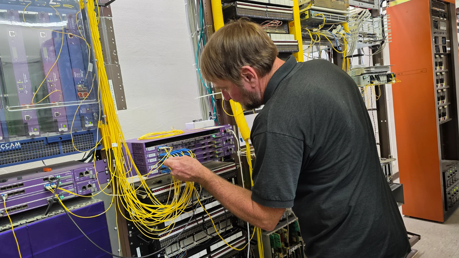A BPS technician patching fiber in the central office